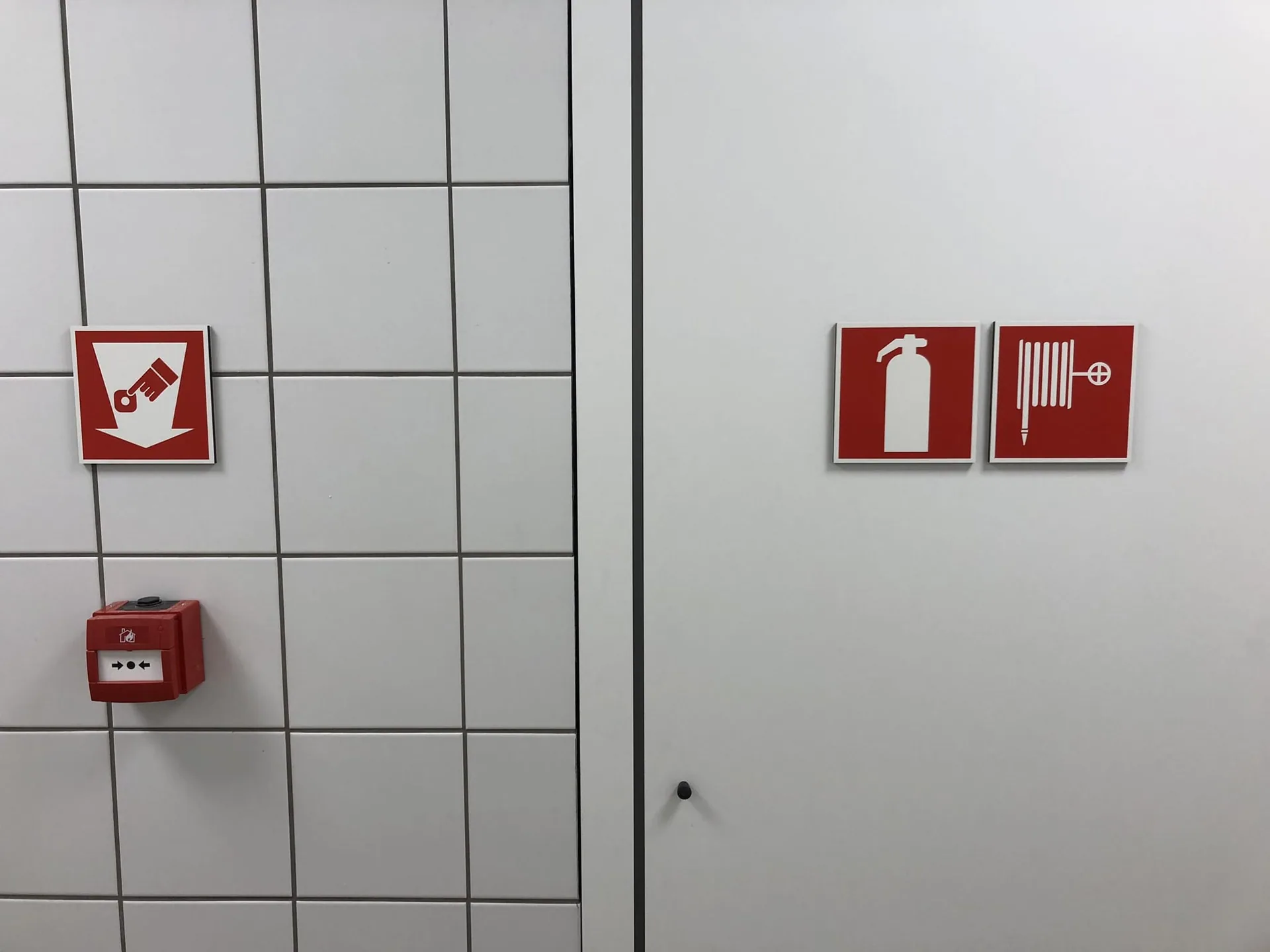 Rode brandveiligheidssignalen op een tegeltjeswand