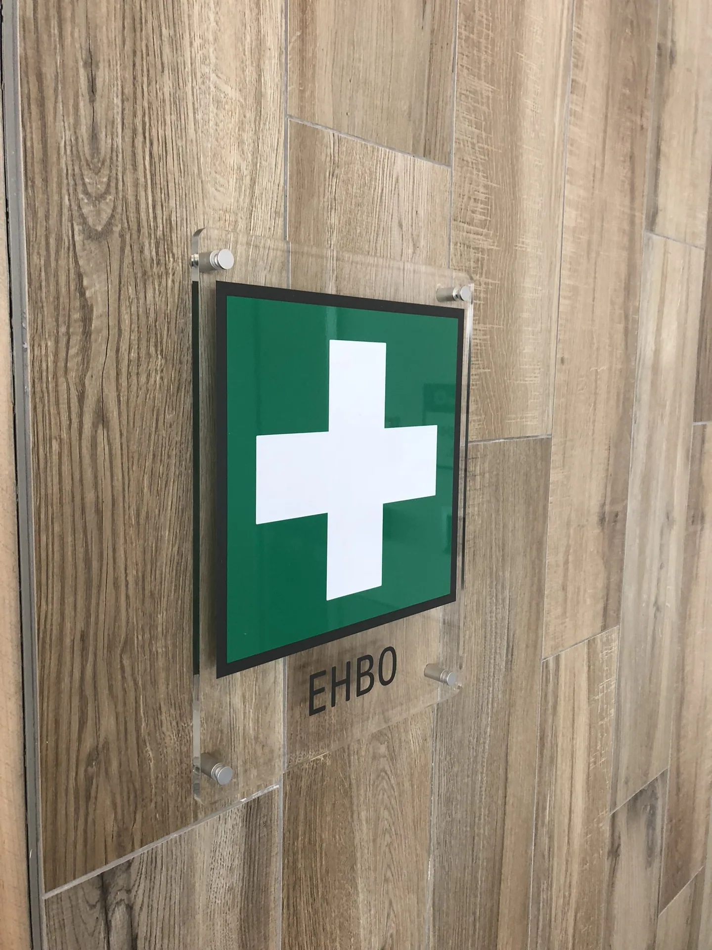 Groen EHBO-kruis op een houten wand