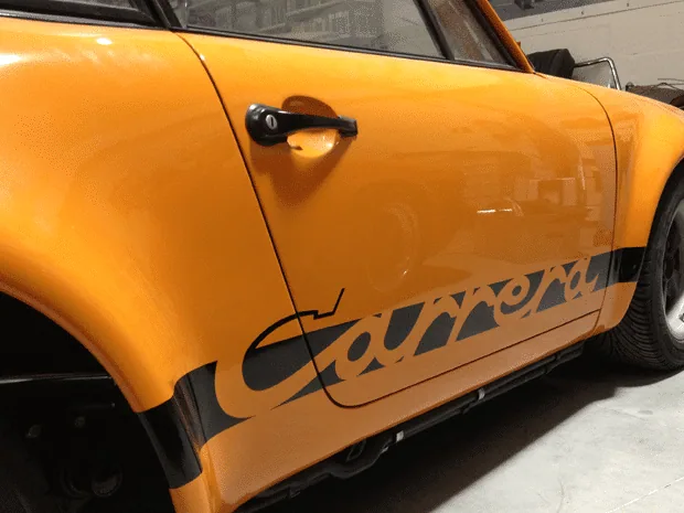 Oranje Porsche met striping op het portier