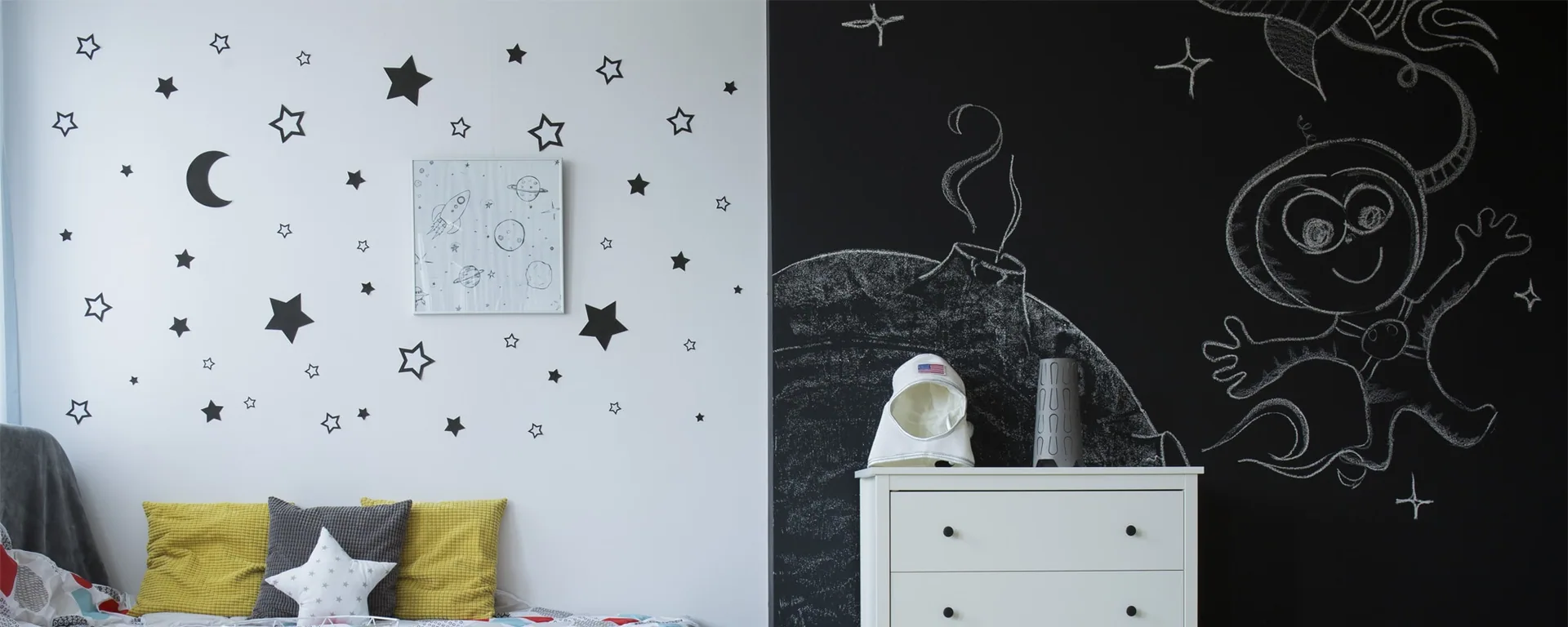 Kinderzimmer mit Sternenfolie am Fenster und einer Tafelwandmalerei